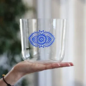 Kirkas kristallinen äänimalja, jossa on kolmannen silmän chakrakuvio